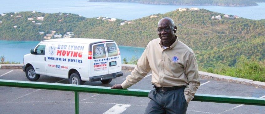 A man standing next to a white van on the side of a road.